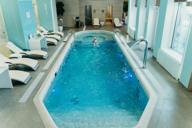 Bright indoor spa pool with lounge chairs and calm atmosphere, ideal for relaxation.