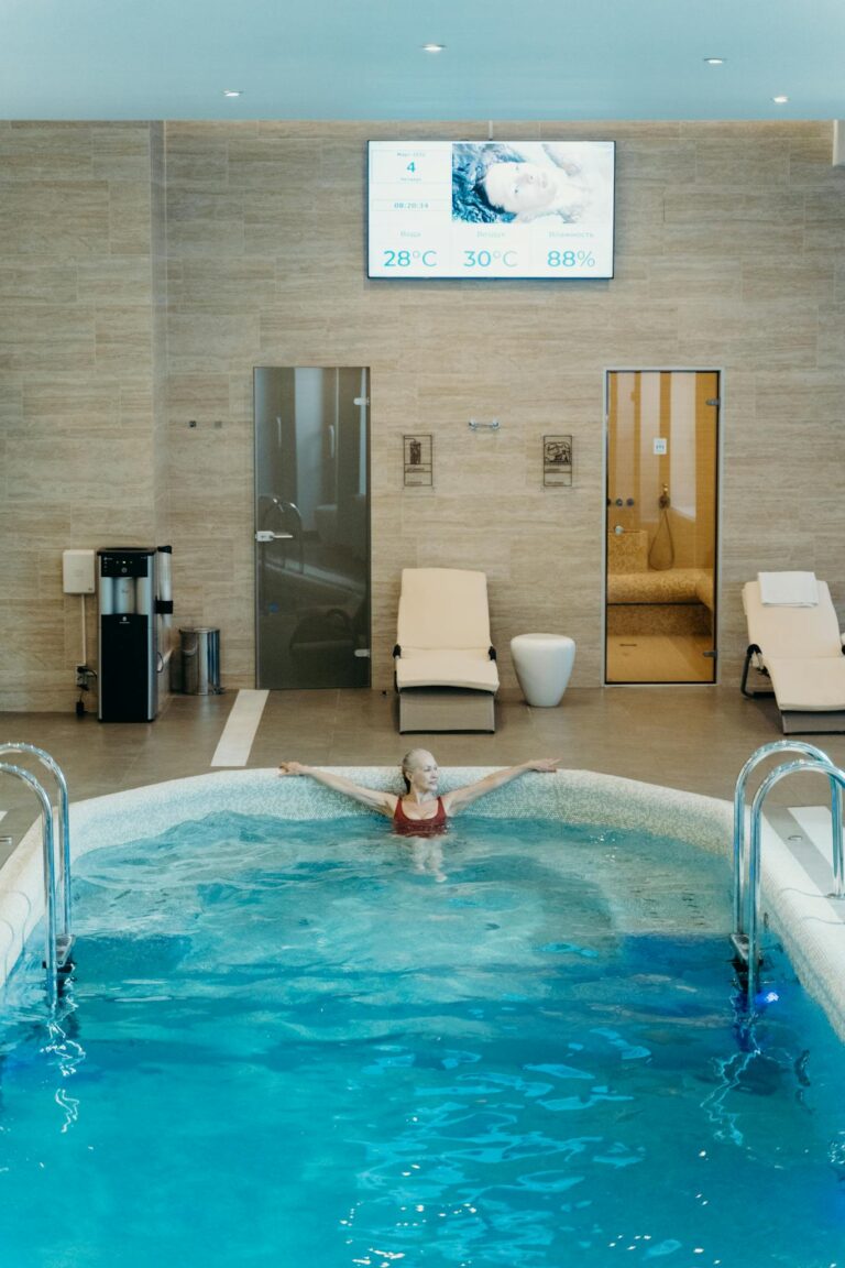 Woman enjoying leisure time in an indoor swimming pool, surrounded by modern amenities.