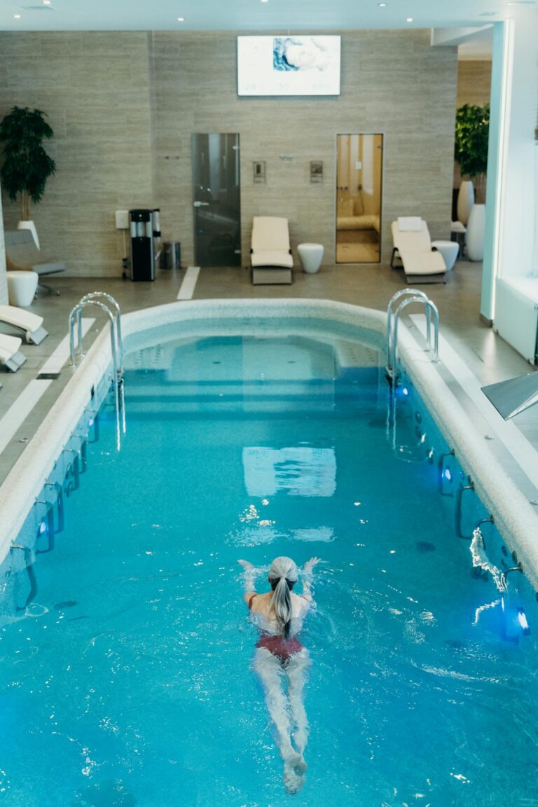 Woman swimming in a luxury indoor spa pool, perfect for relaxation and wellness.